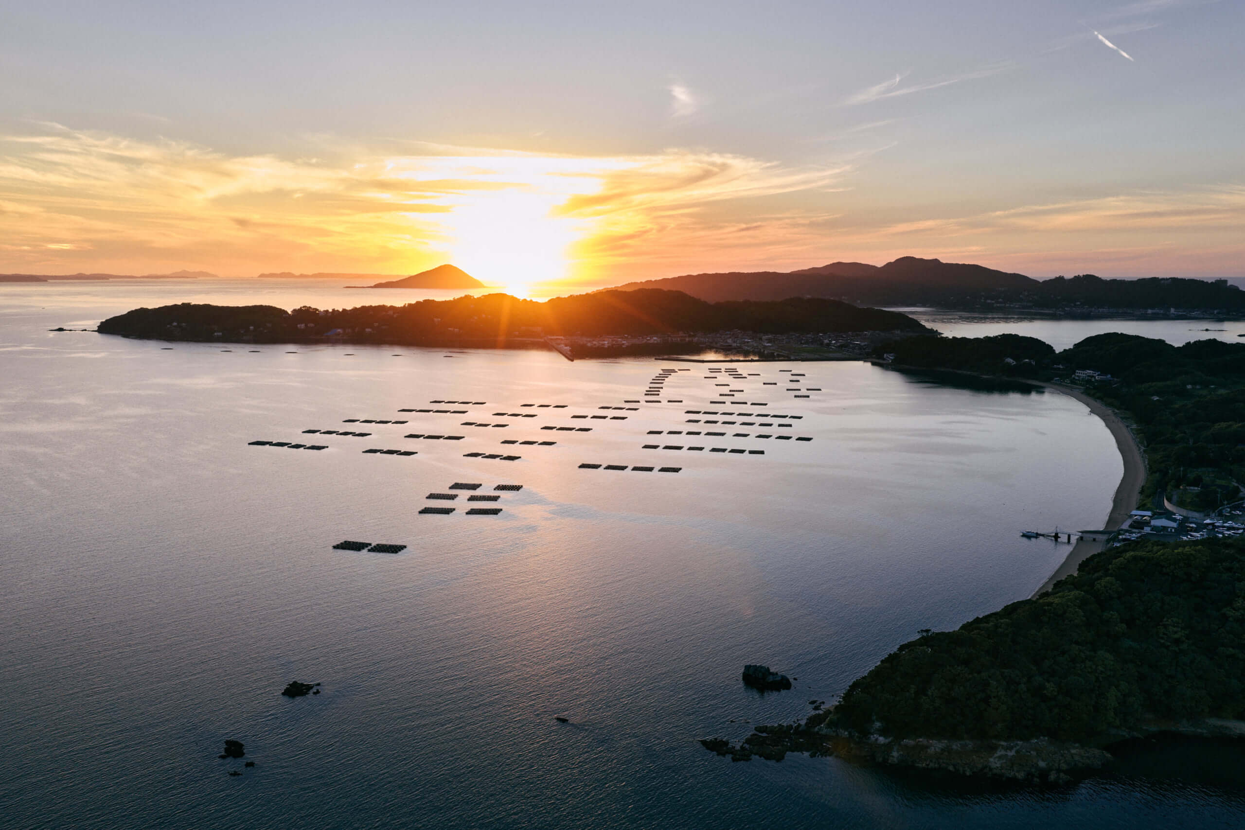 夕暮れの海と沈む太陽が織りなす、静かで贅沢なひとときを捉えた写真